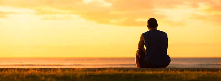 silhouette of a person looking at a sunset