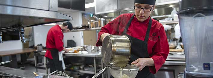 Woman cooking in college skilled trade program
