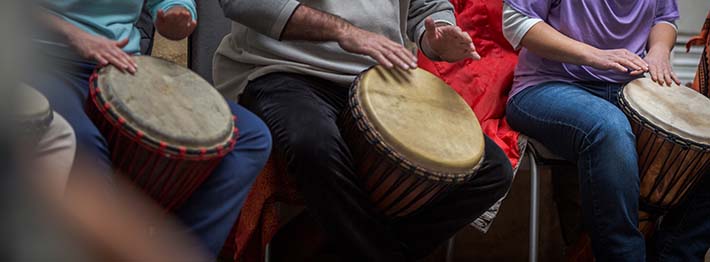 Seniors participating in music therapy using drums