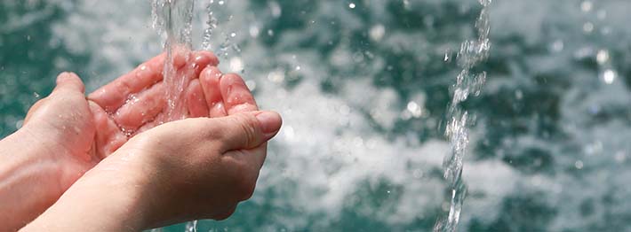 Hands being washed under a stream of water