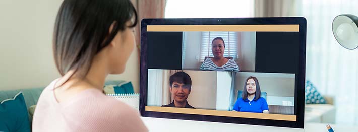 Woman in virtual job interview on her computer with three panelists