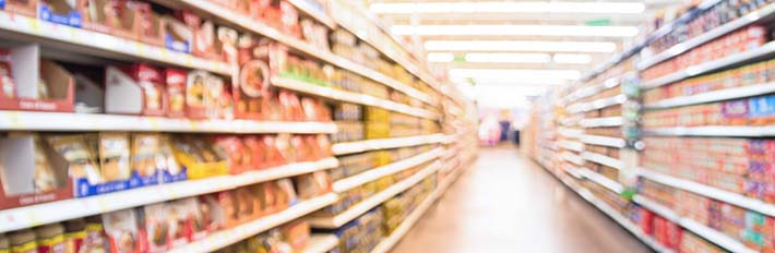 blurred image of stocked grocery store shelves