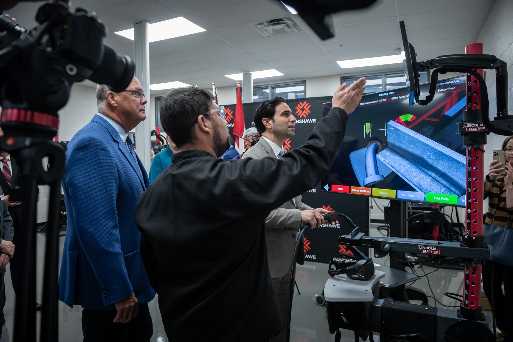 MP for London North Centre Peter Fragiskatos tries virtual welding simulator as MPP Rob Flack looks on.