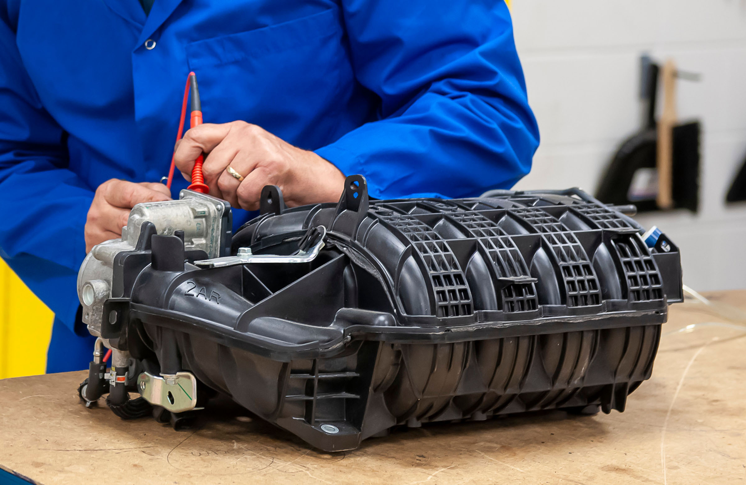Student testing diesel engine intake part