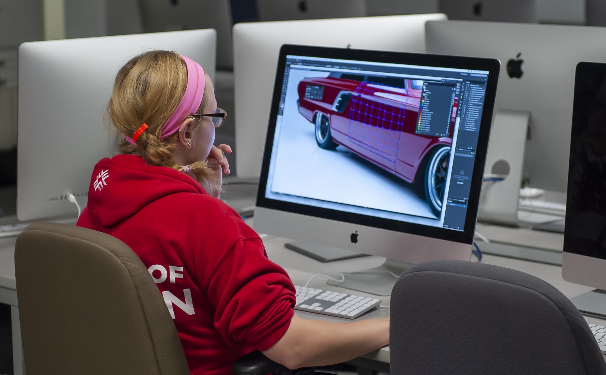 Graphic design student working in computer lab on illustration