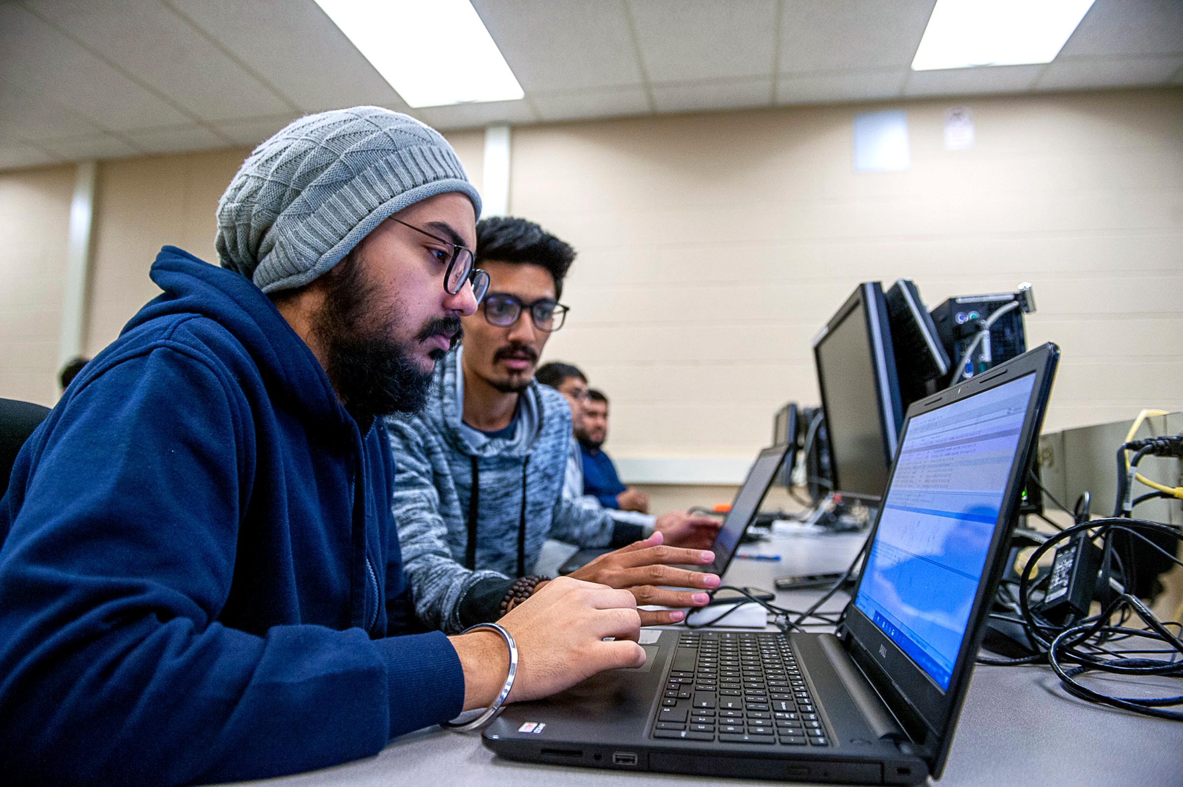 Two guys working on laptop coding
