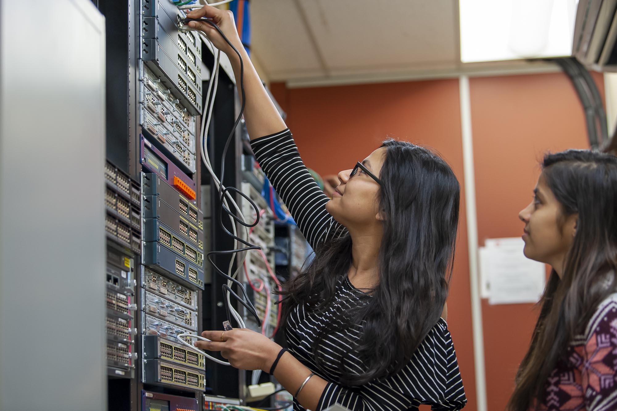 Student changing wires in networking lab