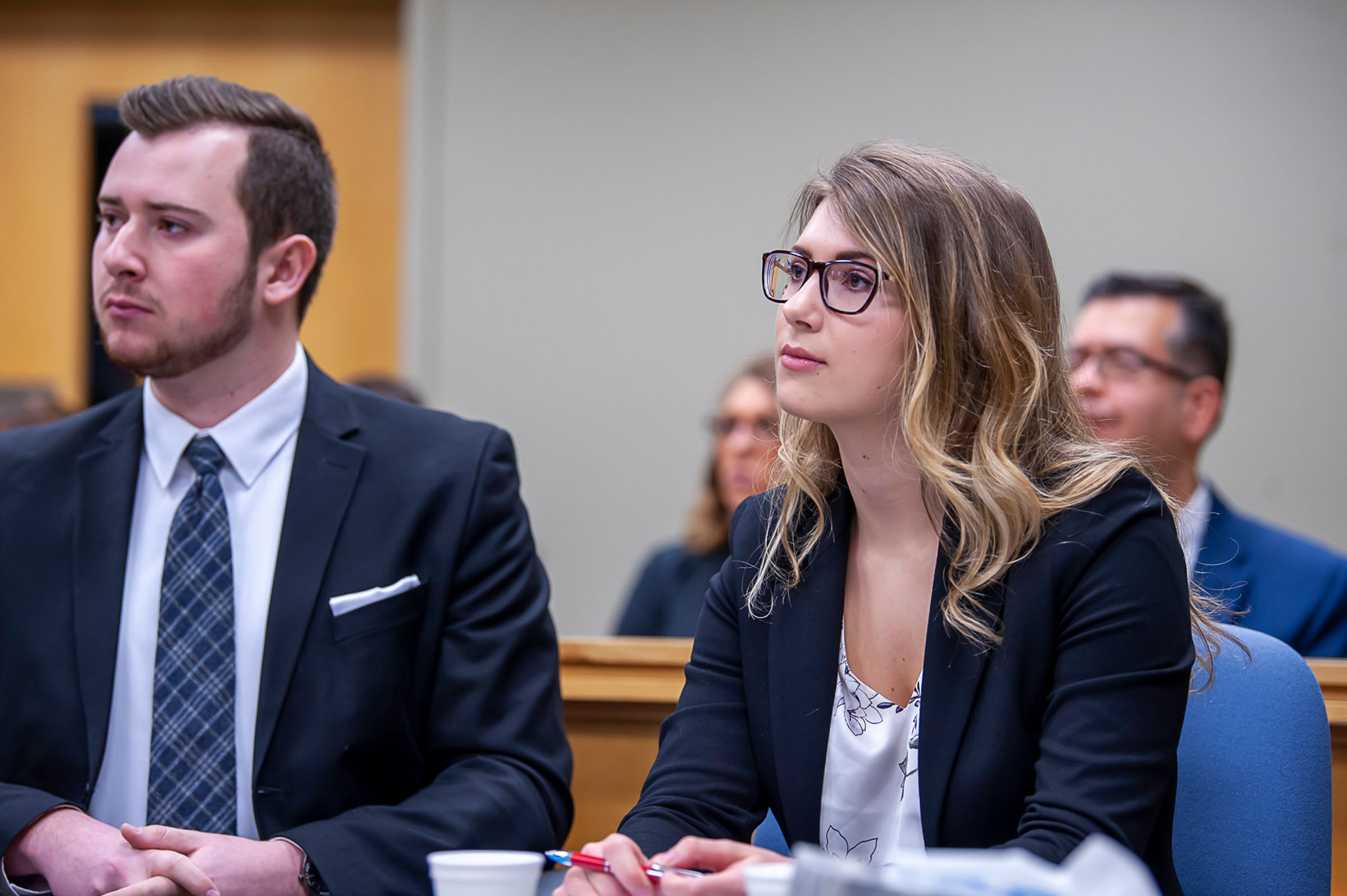 Two students in mock trial looking at judge