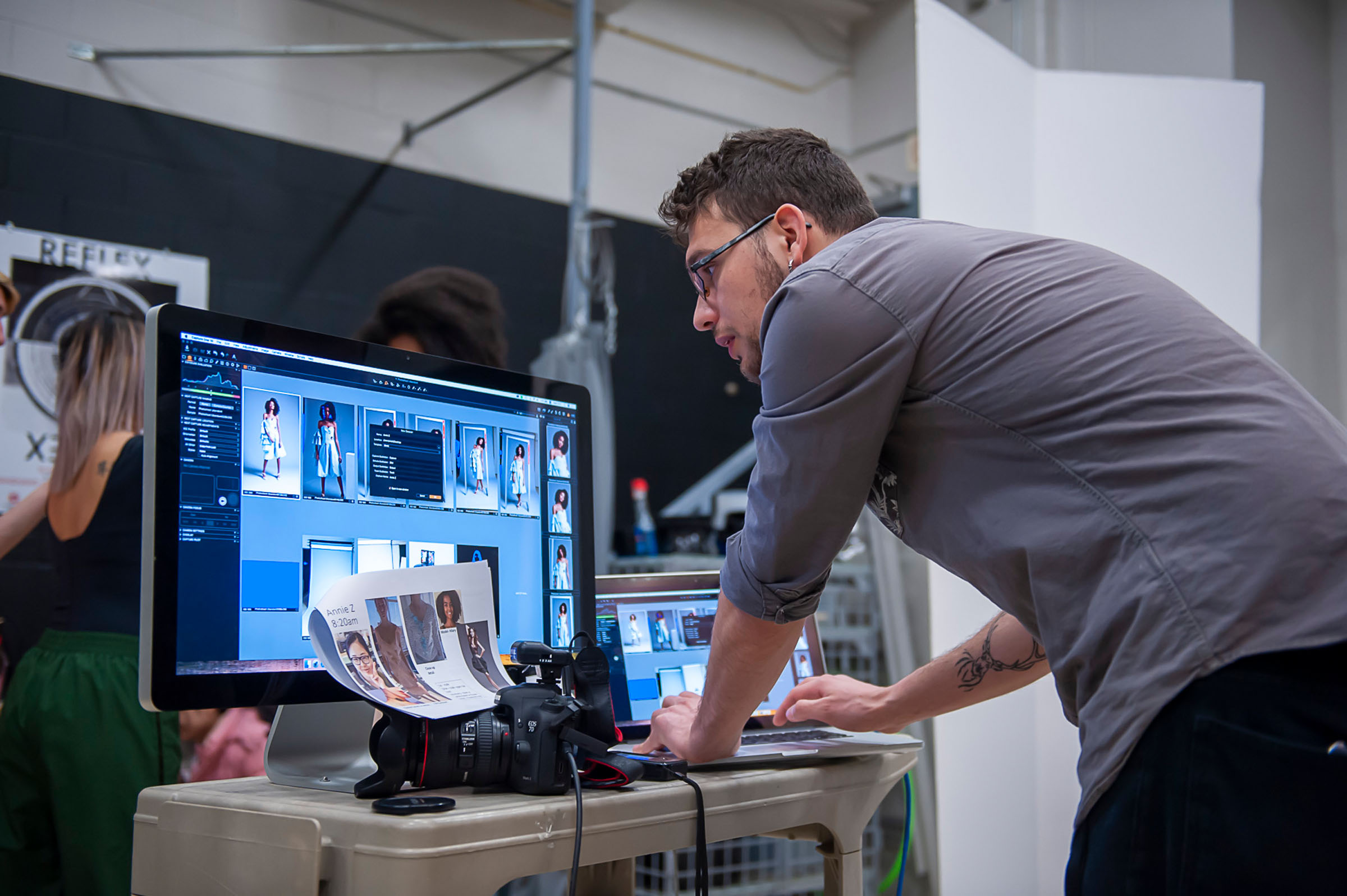 Photography student looking at proofs of images on computer screen