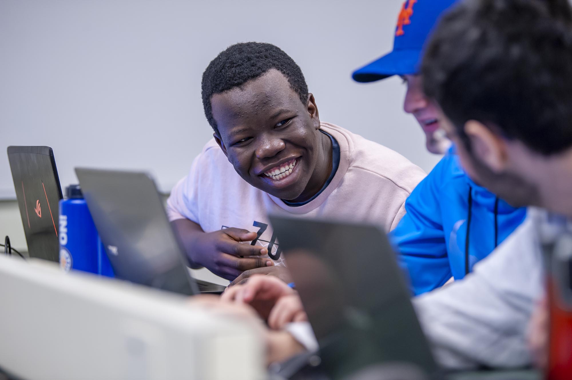 Students happily chatting and working on laptops in computer lab