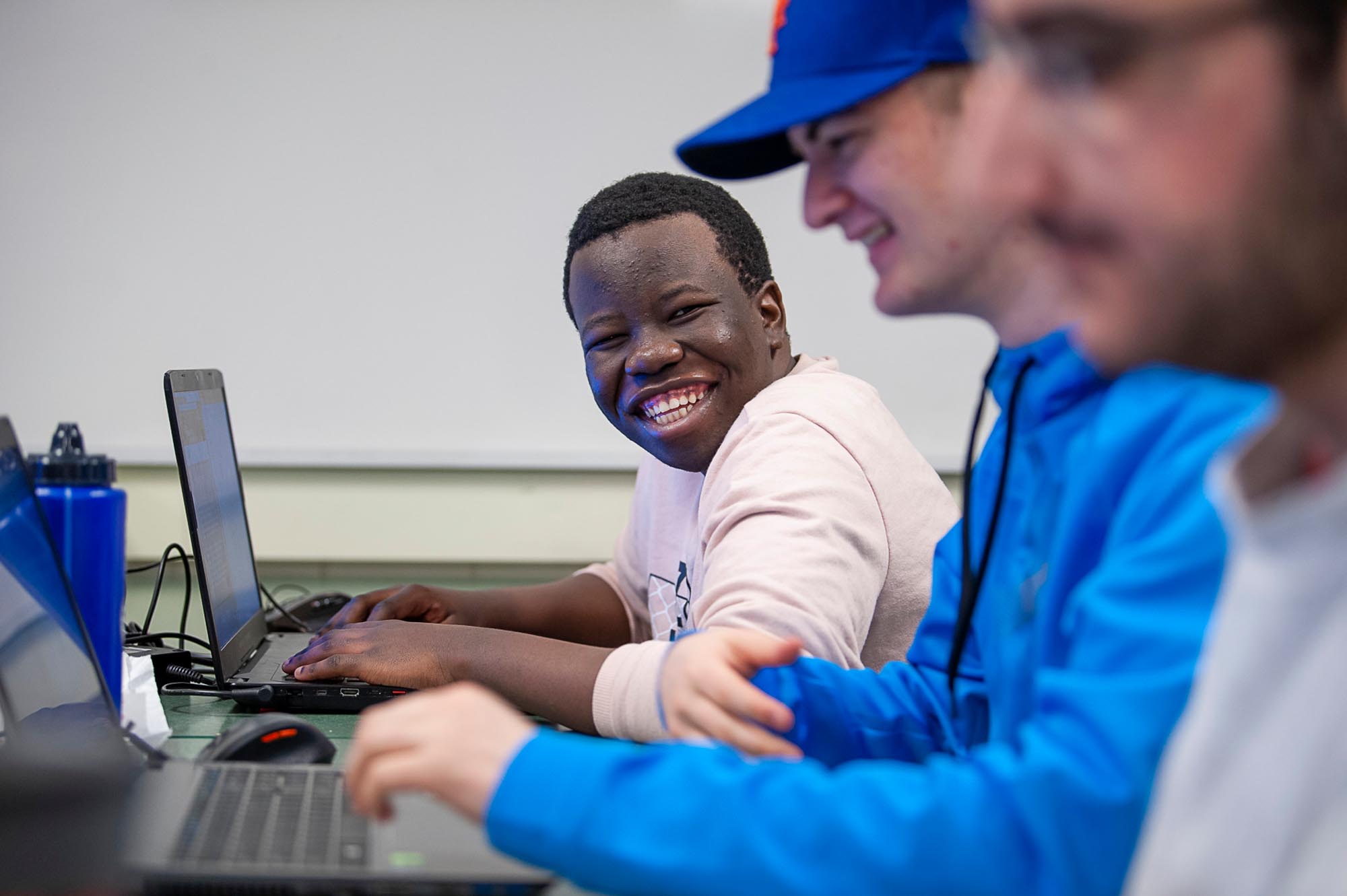 Student smiling at camera in computer lab