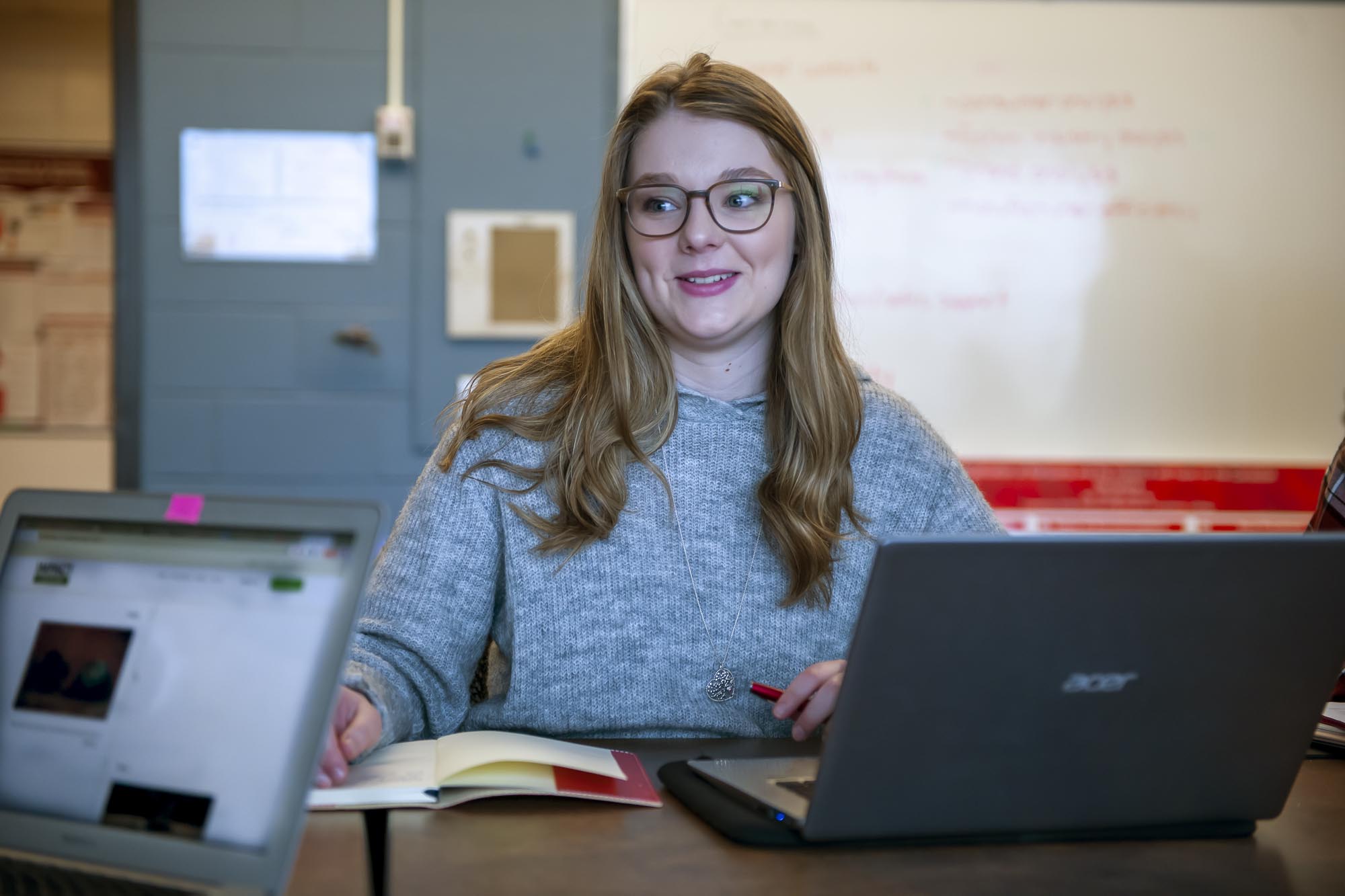 Business Administration Marketing student, sitting at conference table with laptop