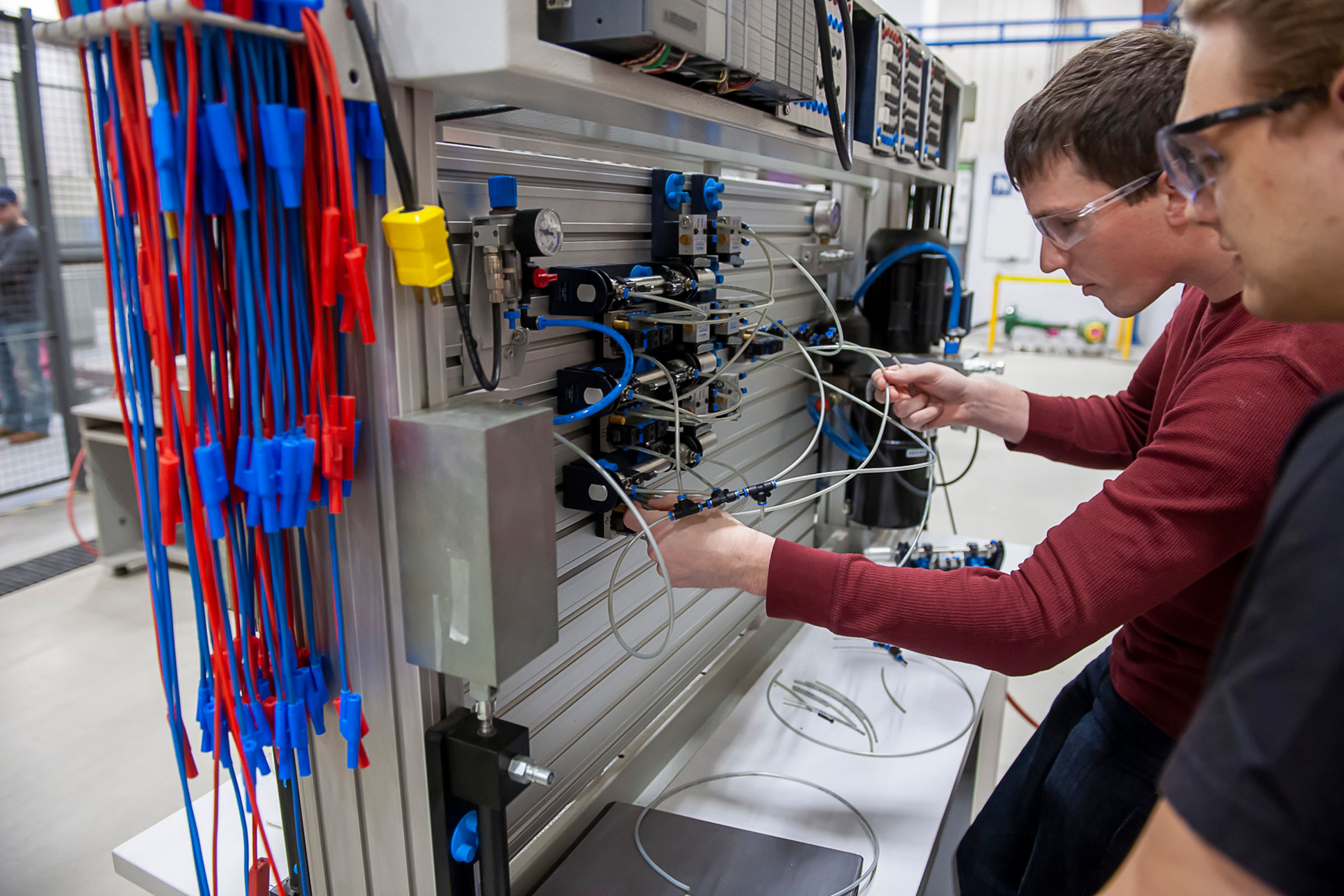 Two guys working on electrical board