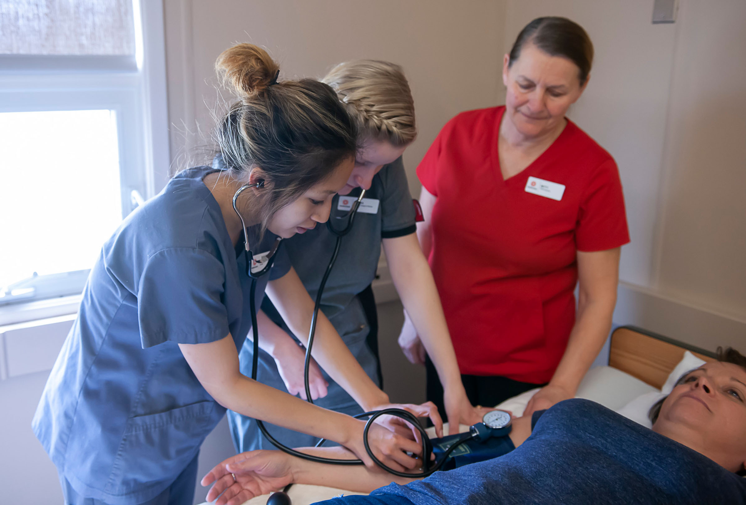 Two students learning from PSW teacher