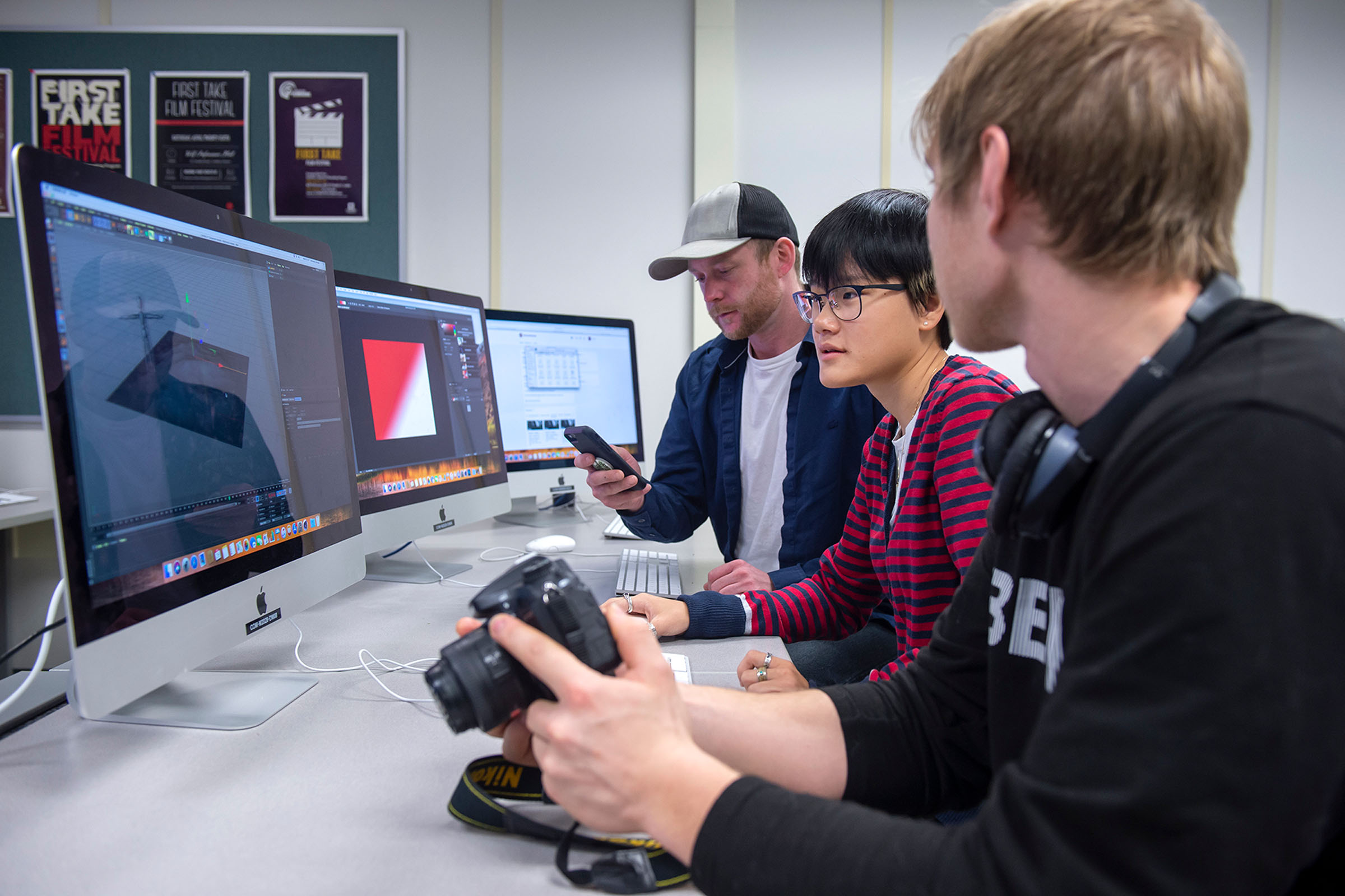 Three students with cameras and computer