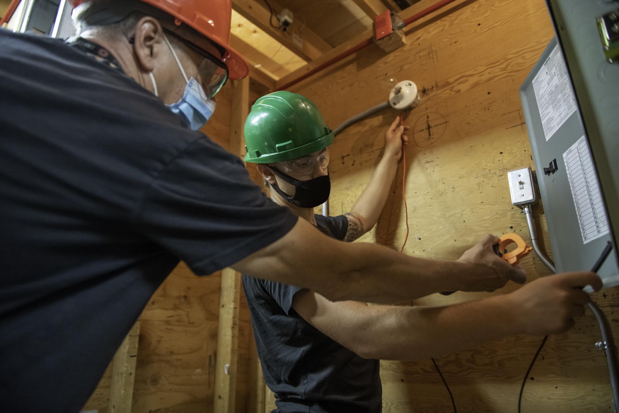 Instructor helping student with electric wiring