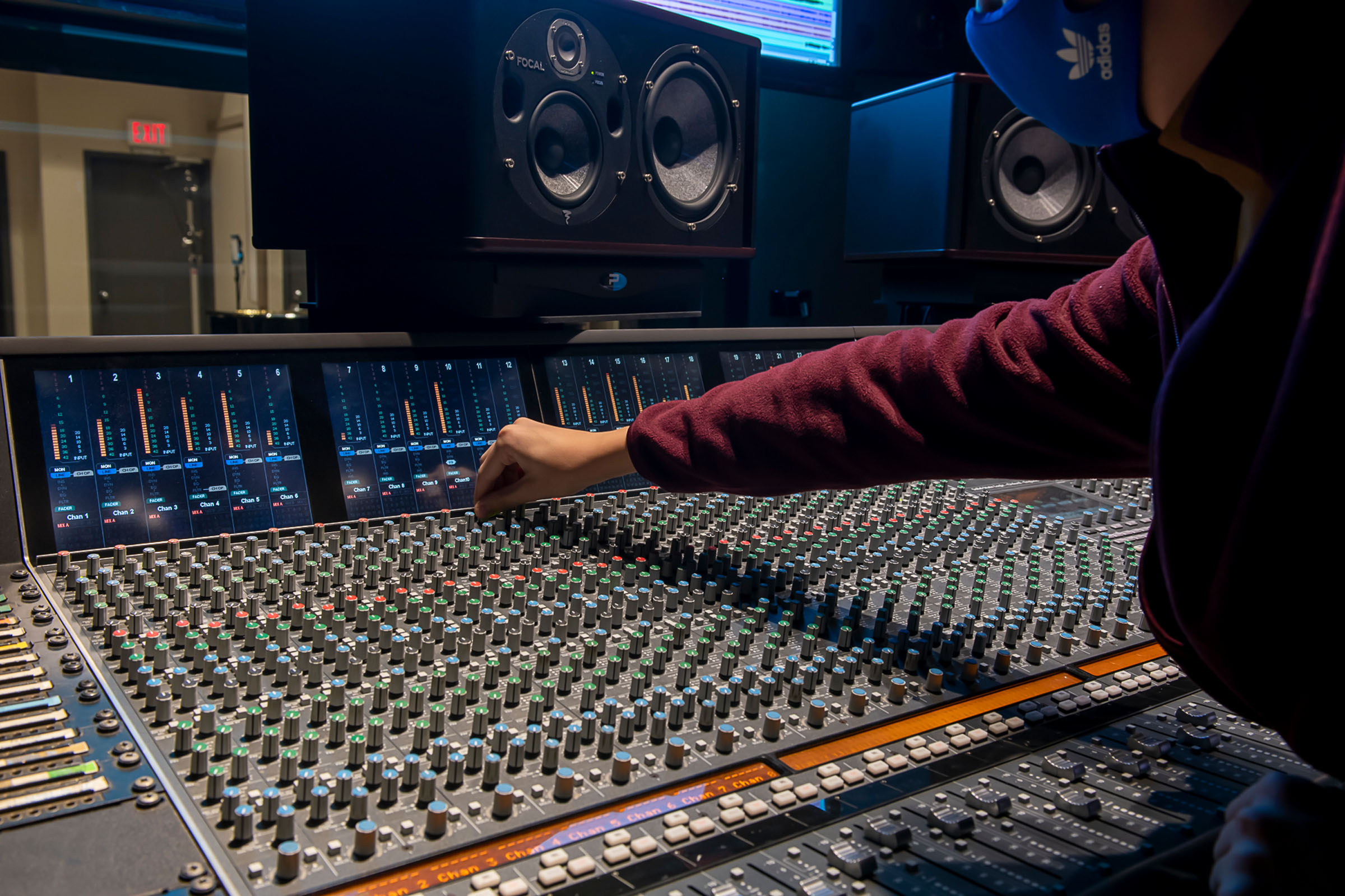 Student working on sound board in a recording studio