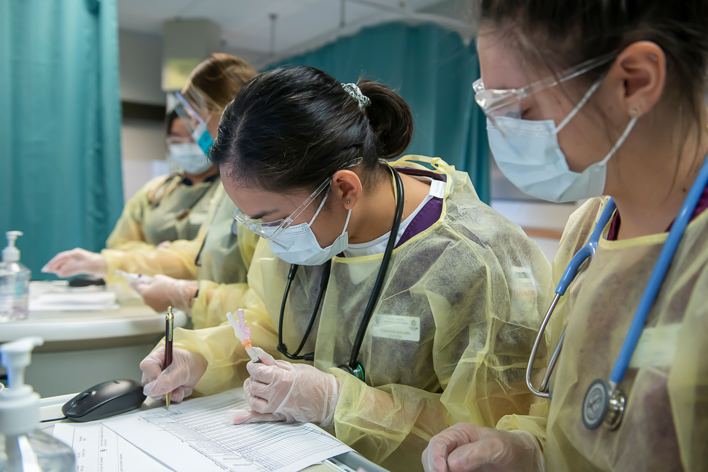 Nursing student in PPE taking notes