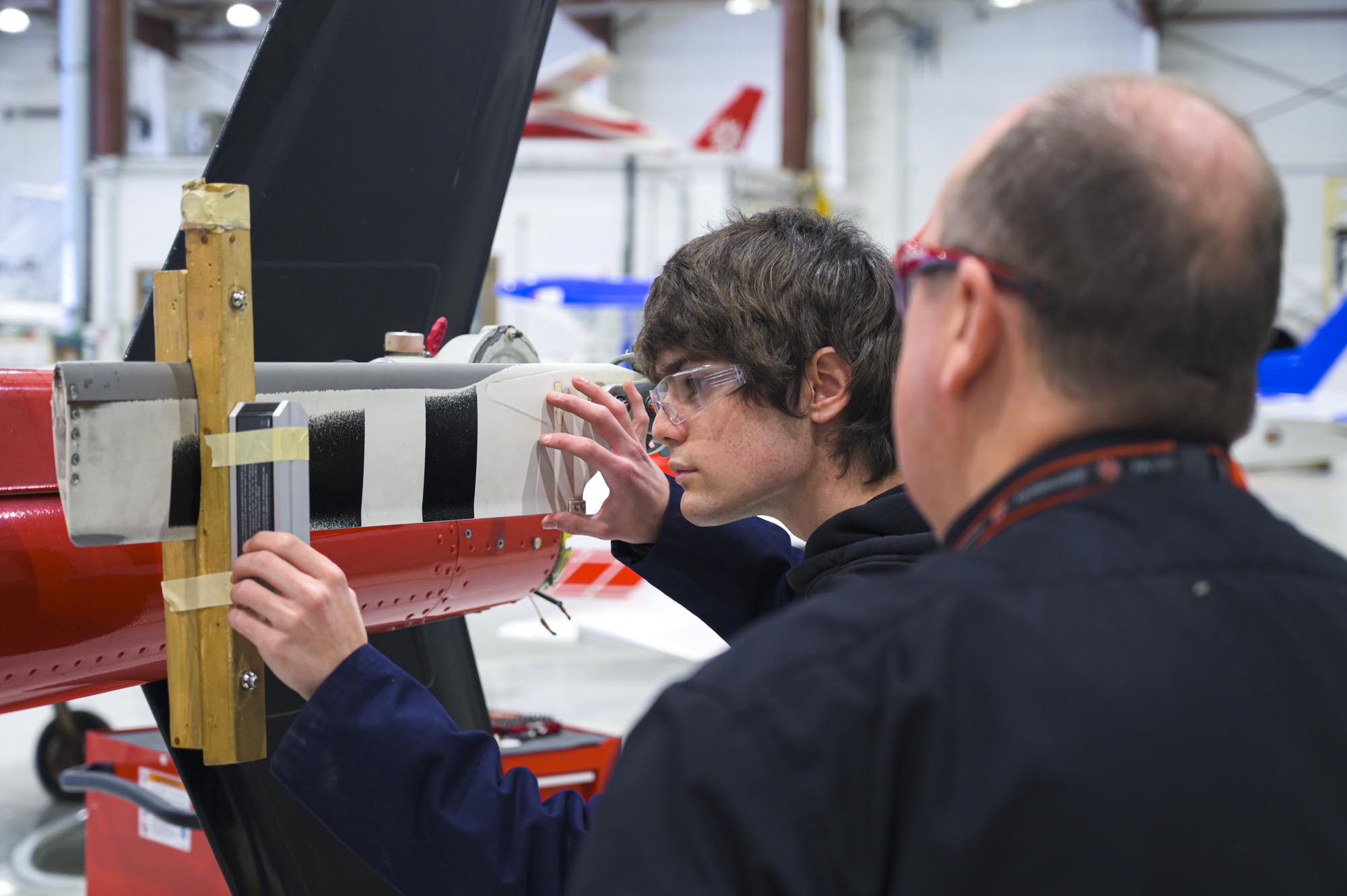 Aviation Technology - Aircraft Maintenance and Avionics student working with the help of instructor in lab