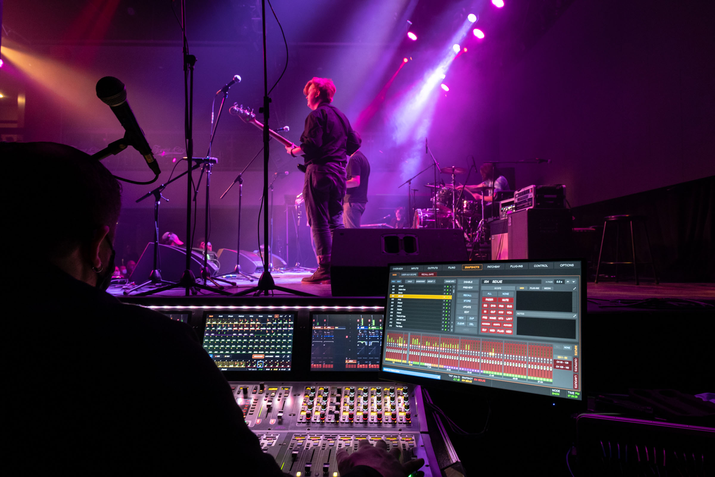Student performing on stage with sound engineer on the side