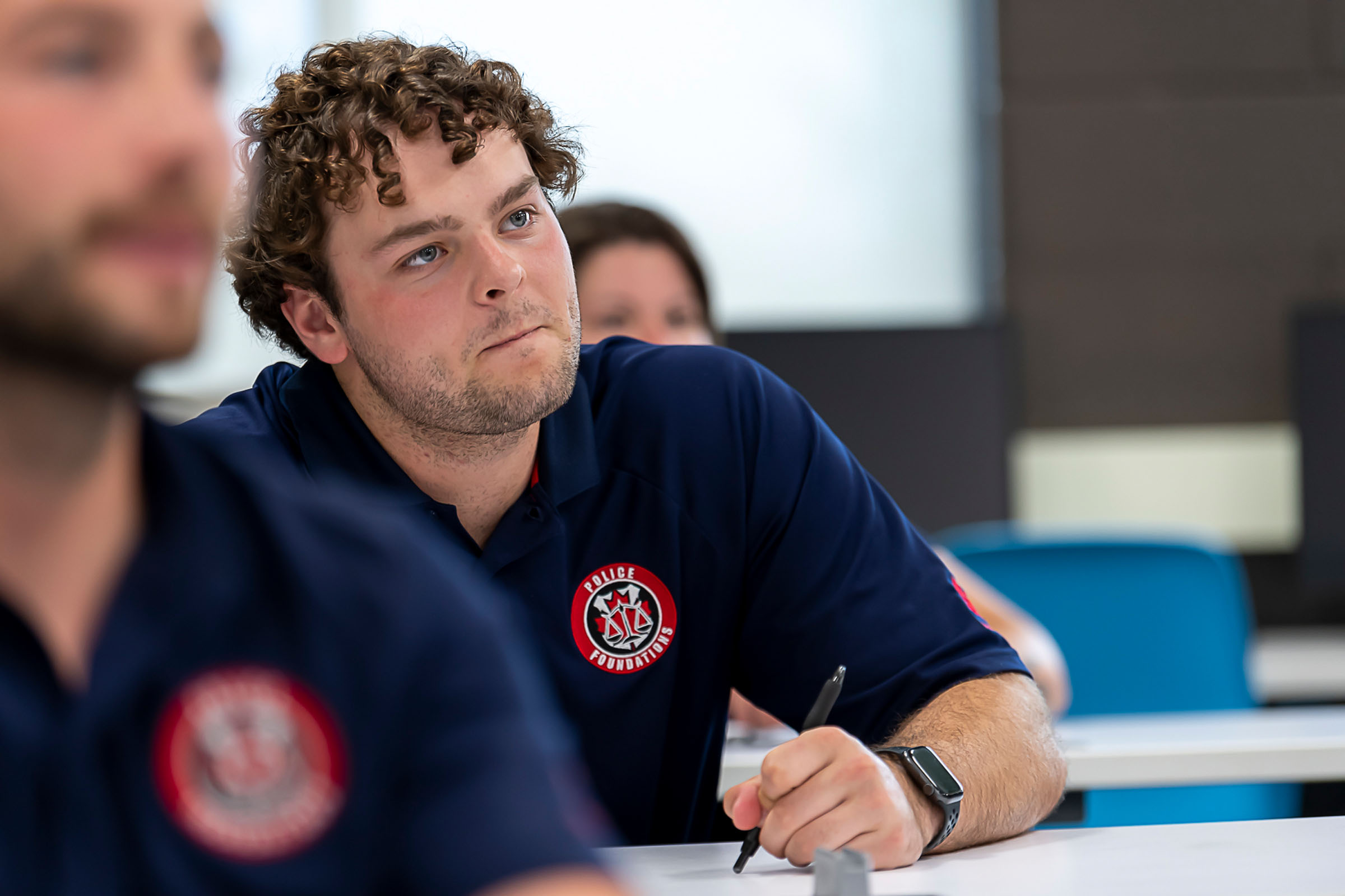 Police foundation student at desk with curious look on his face