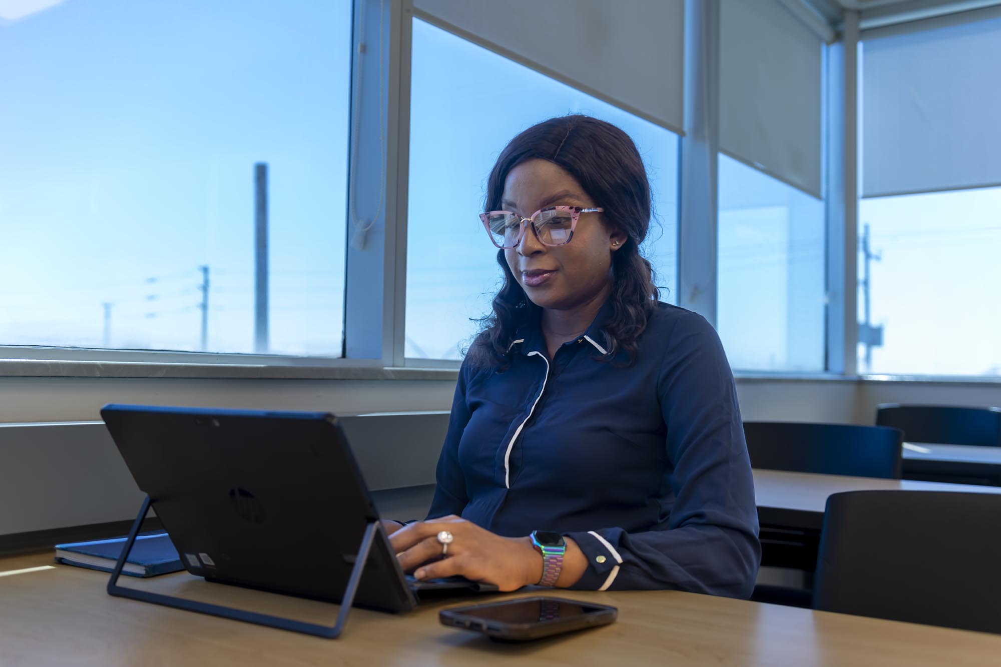 Student sitting in classroom, working on laptop