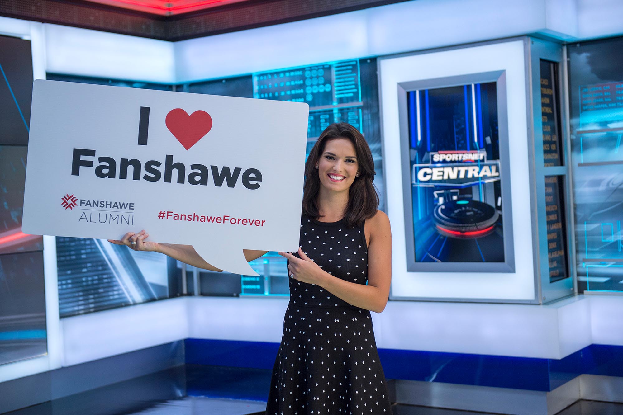 Caroline Cameron holding up the Fanshawe logo