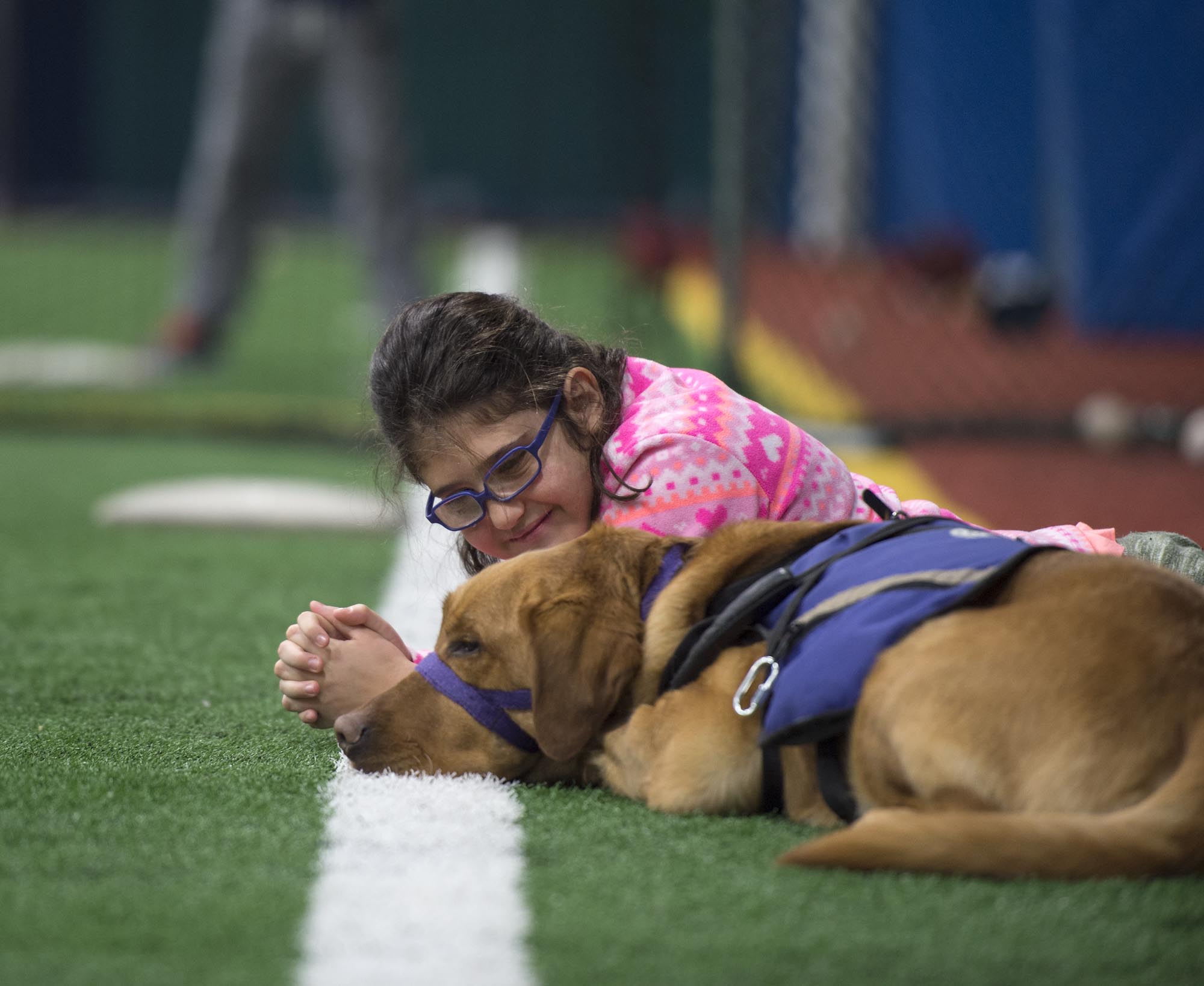 Young girl smiling, sitting with support dog
