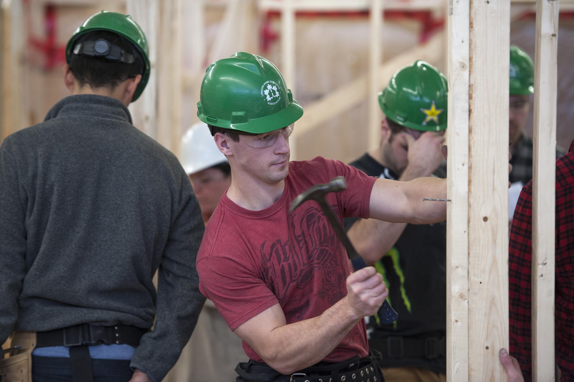 Fanshawe student hammering a nail into frame