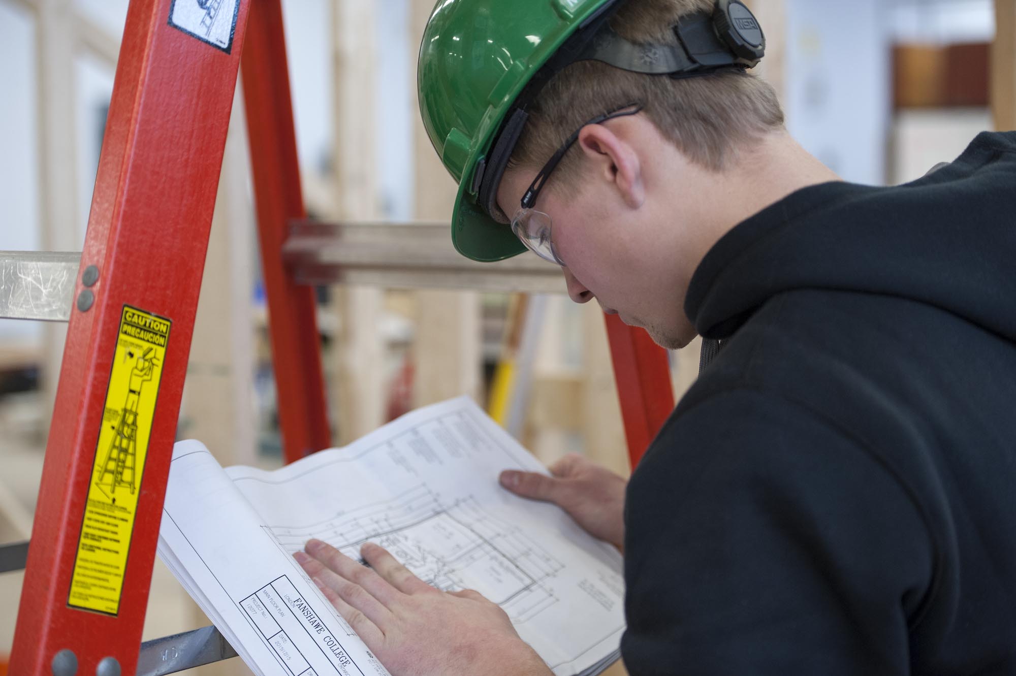 Fanshawe Carpentry student, reviewing plans in workshop