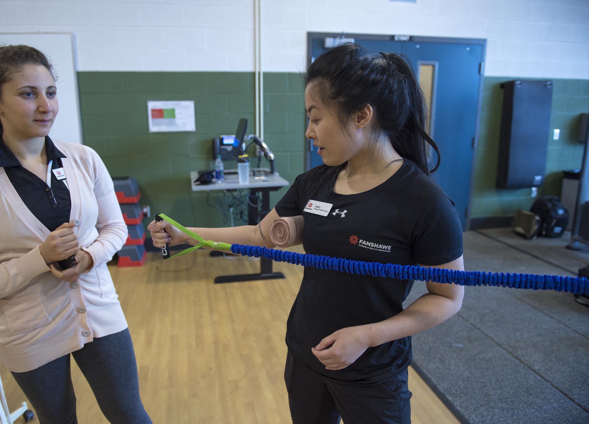 Fitness and Health Promotion student, doing arm exercises with band