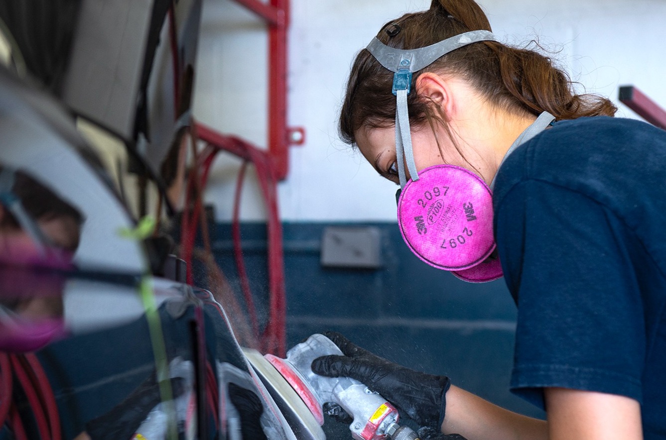Auto body repair apprentice working on a car