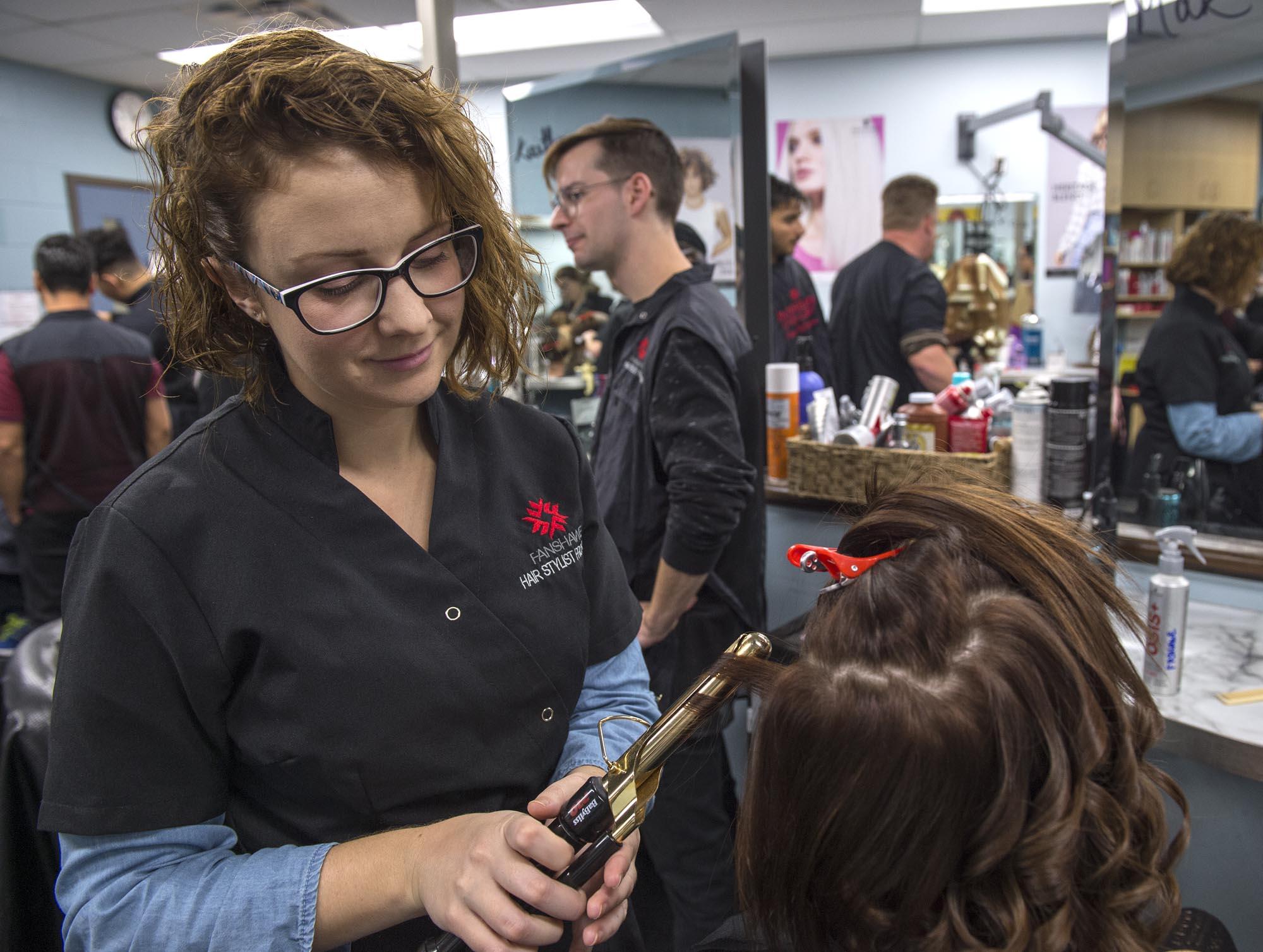 Fanshawe hairstyling student, curling hair of client