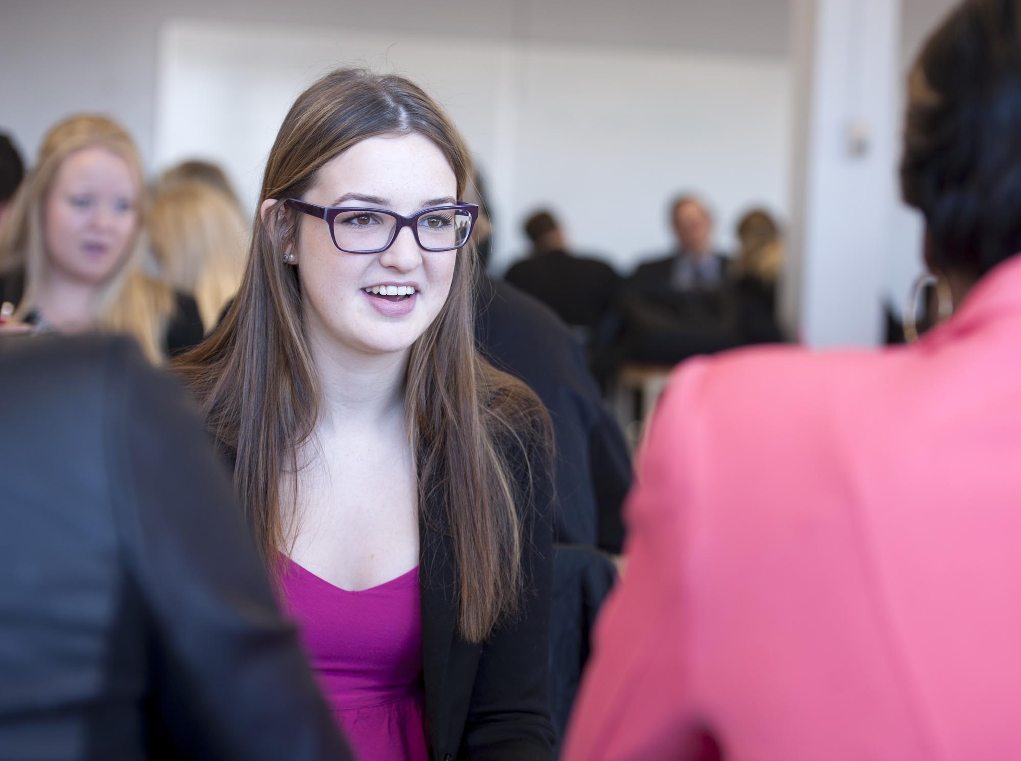 Students in business attire, communicating in groups, classroom