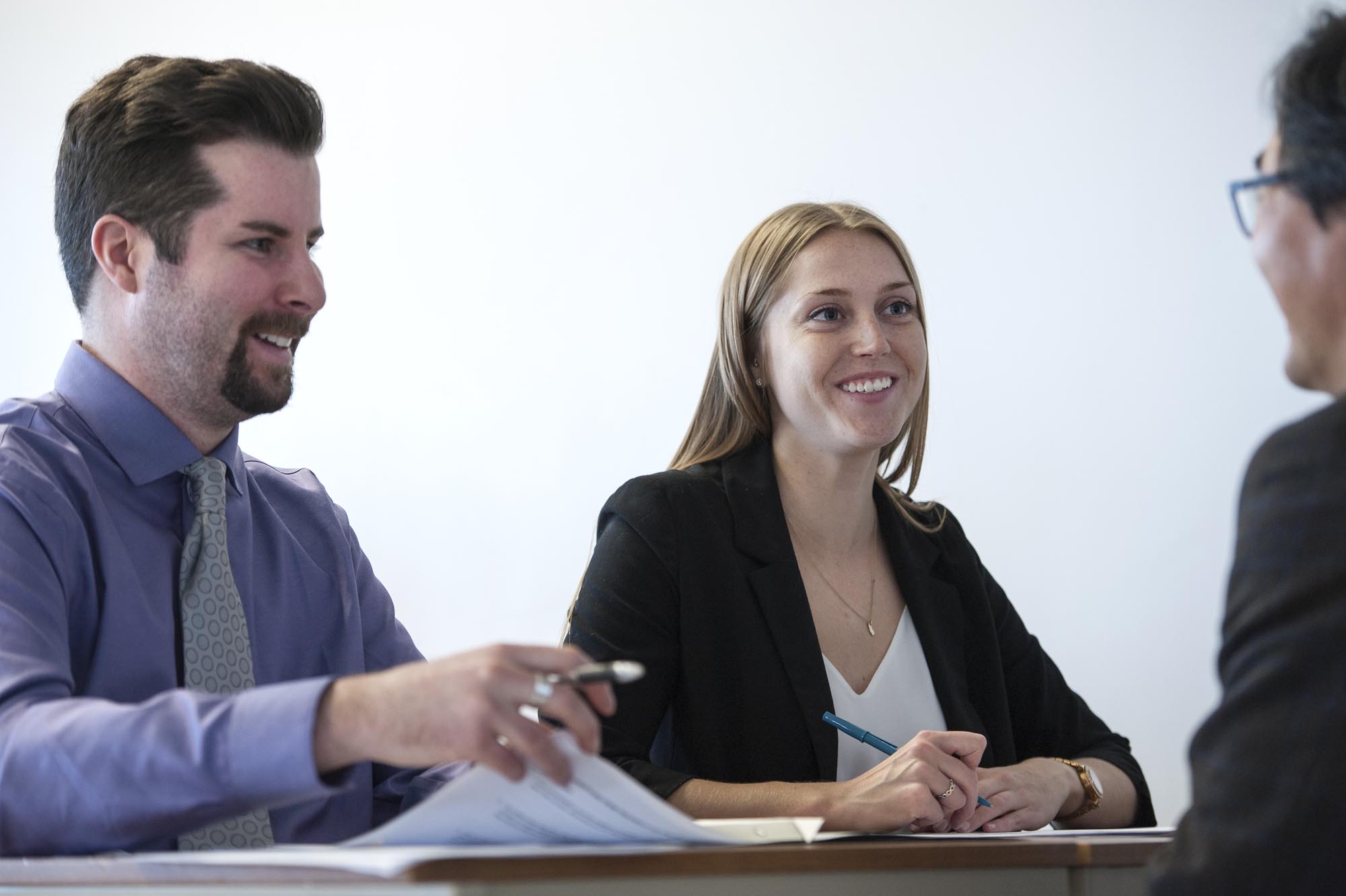 Business students in classroom, collaborating and smiling