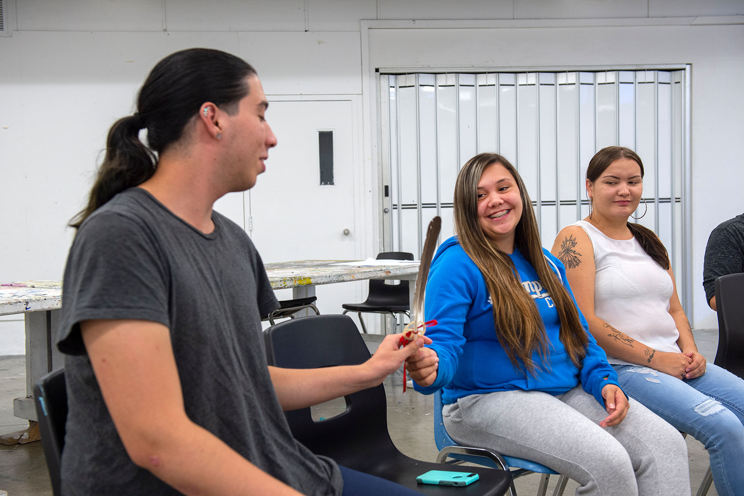 Student sitting a circle passing a feather around