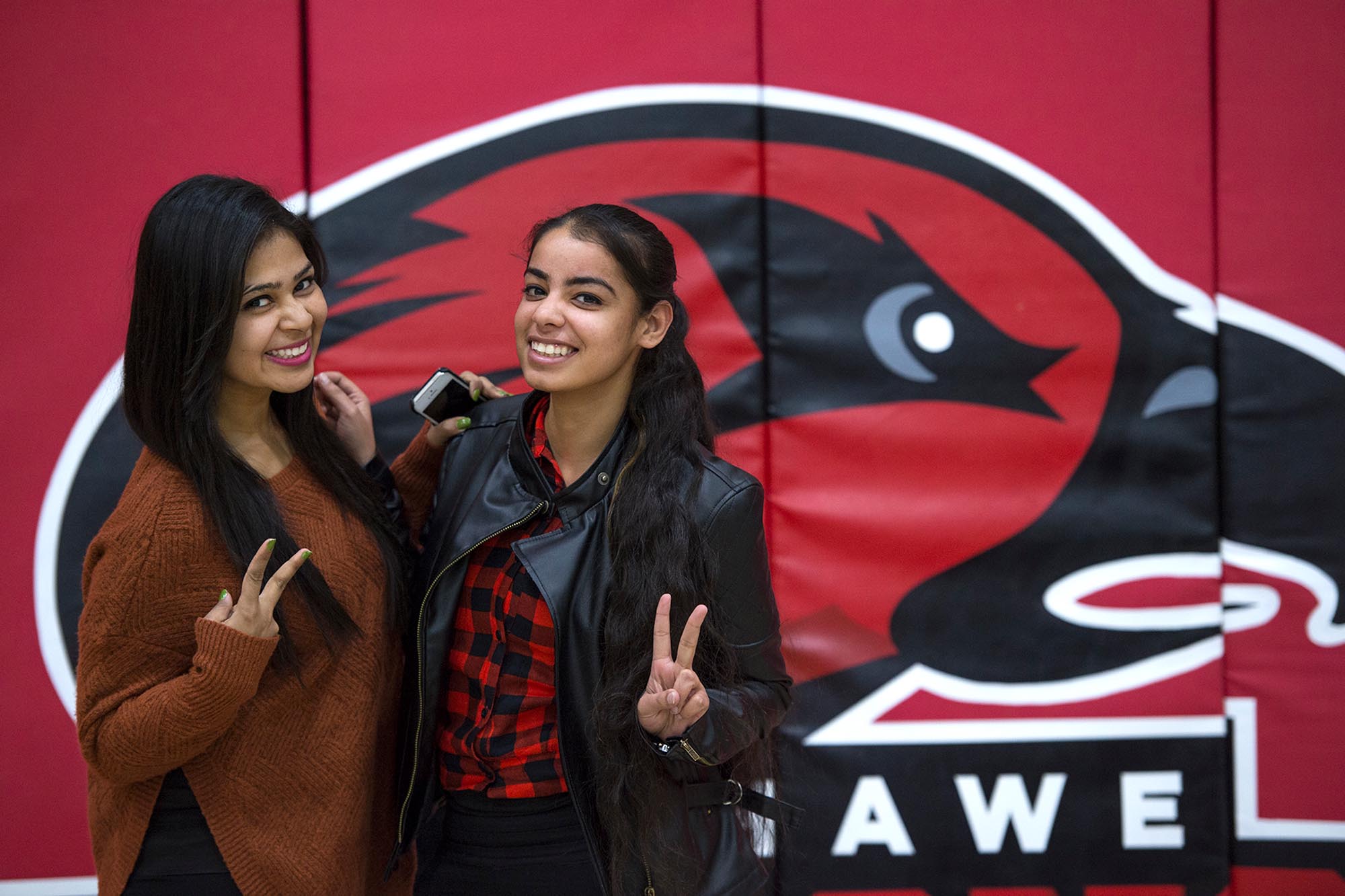 Two girls giving peace symbol posed
