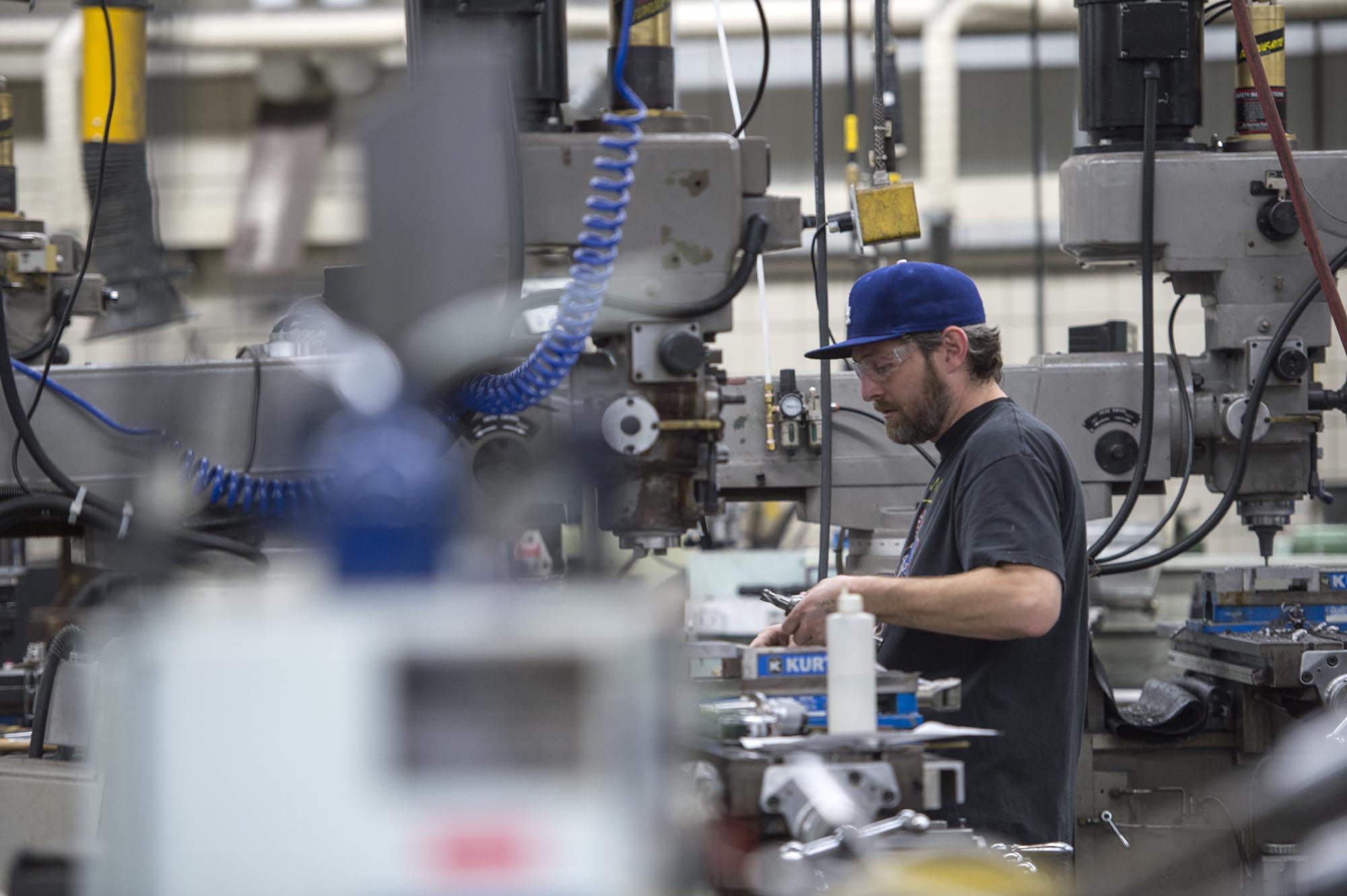 Mechanical Engineering Technician student, working in workshop at a large machine