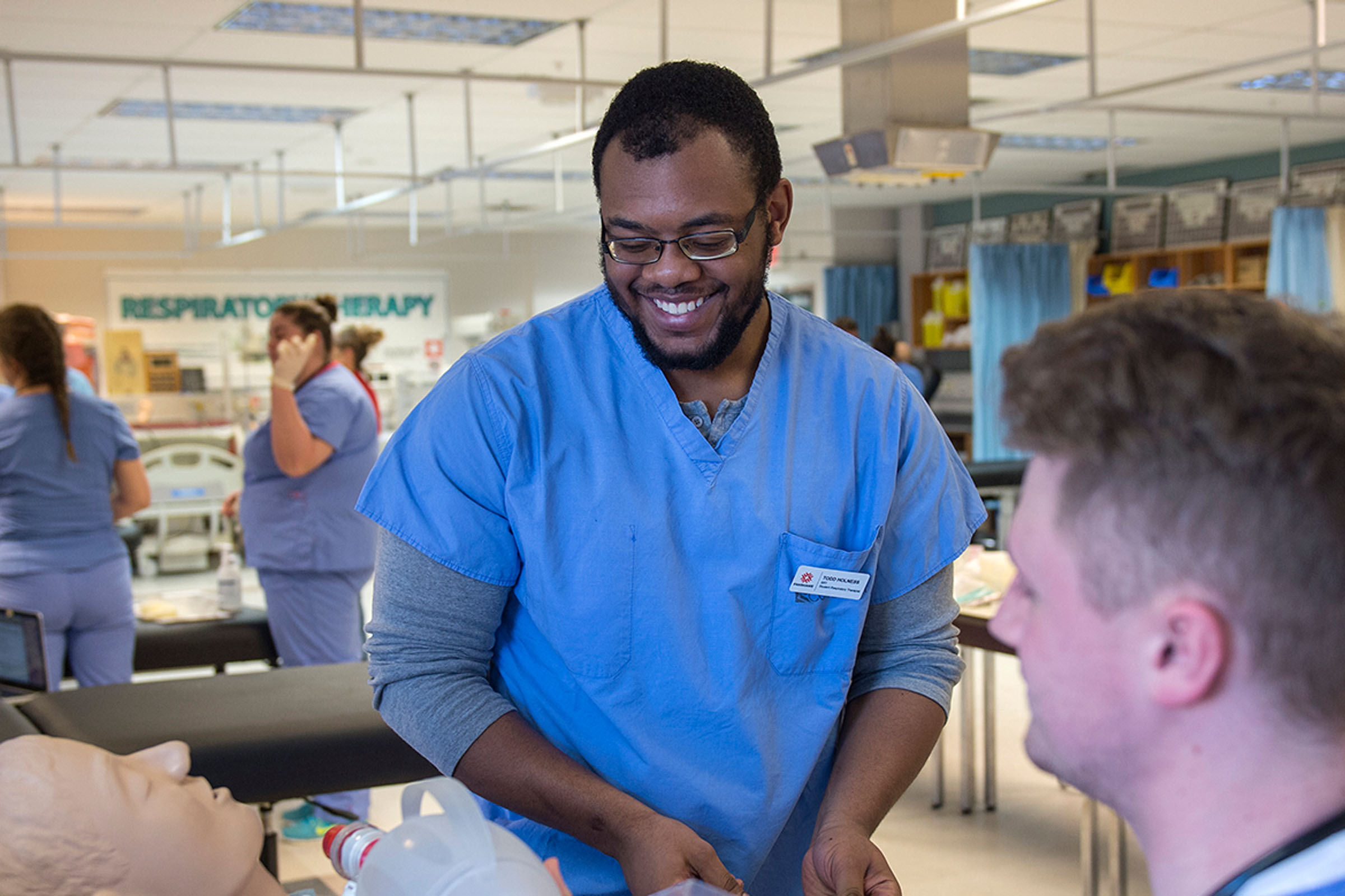 Male nurse student smiling with professor