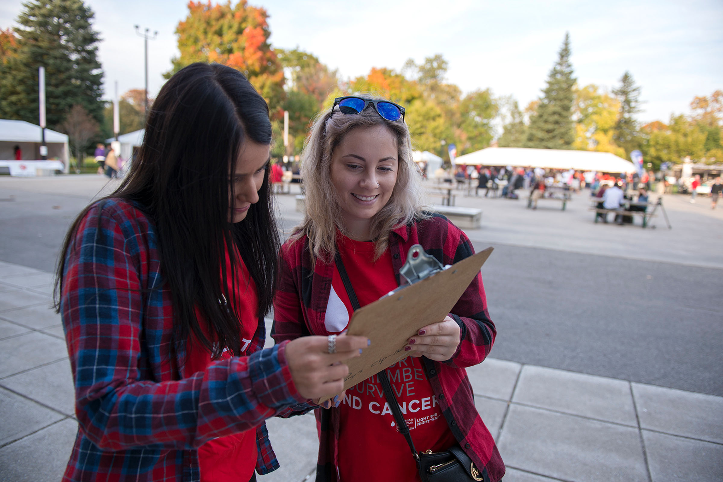 Two event planners working at a charity event with a clipboard in hand