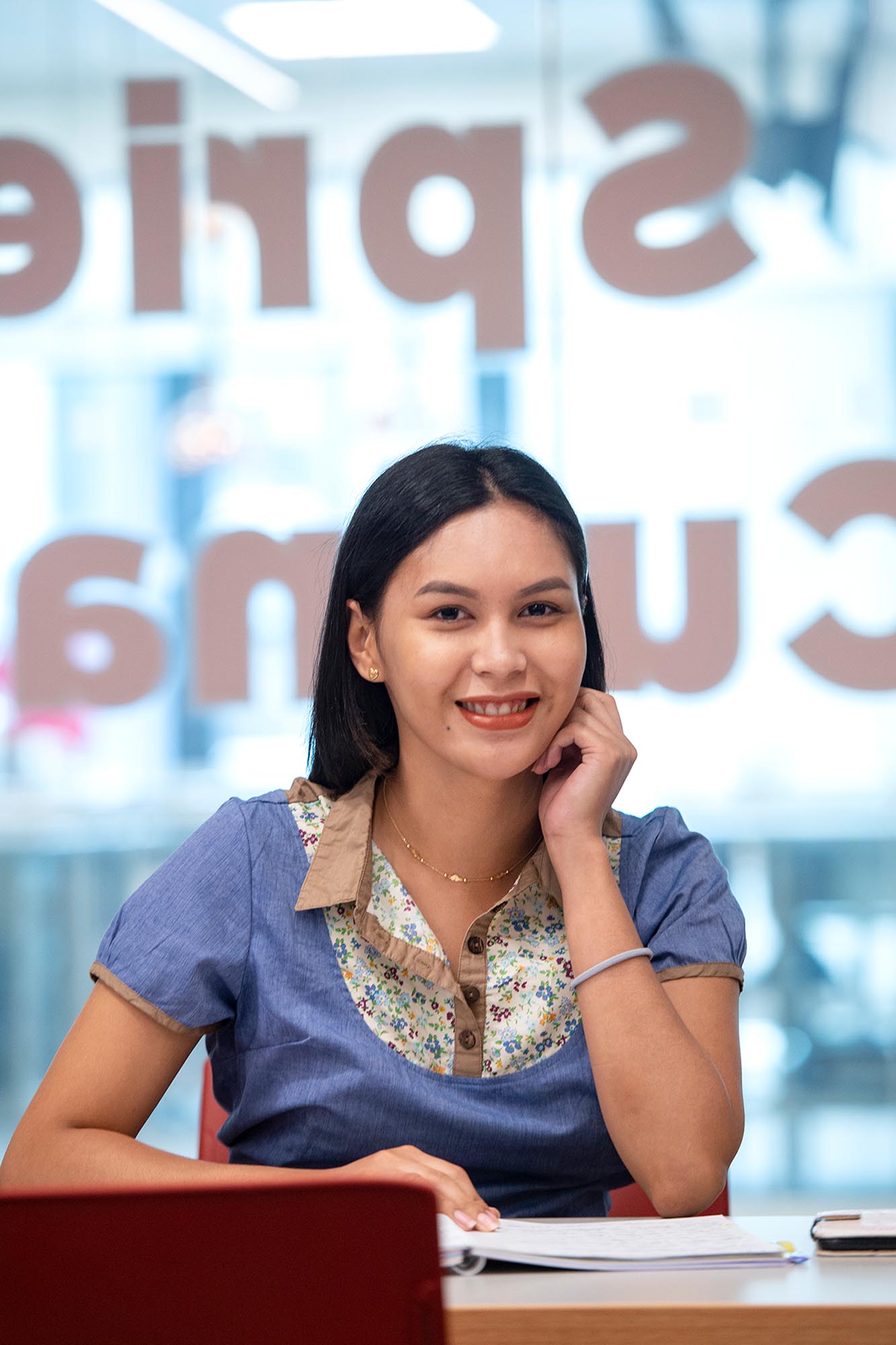 Student smiling at camera sitting at desk