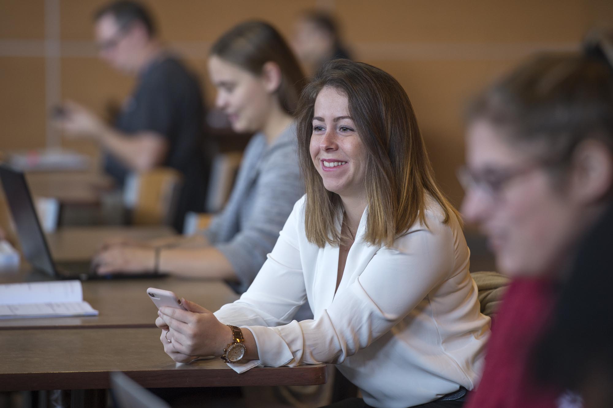 Fanshawe student smiling and sitting with other students in common area