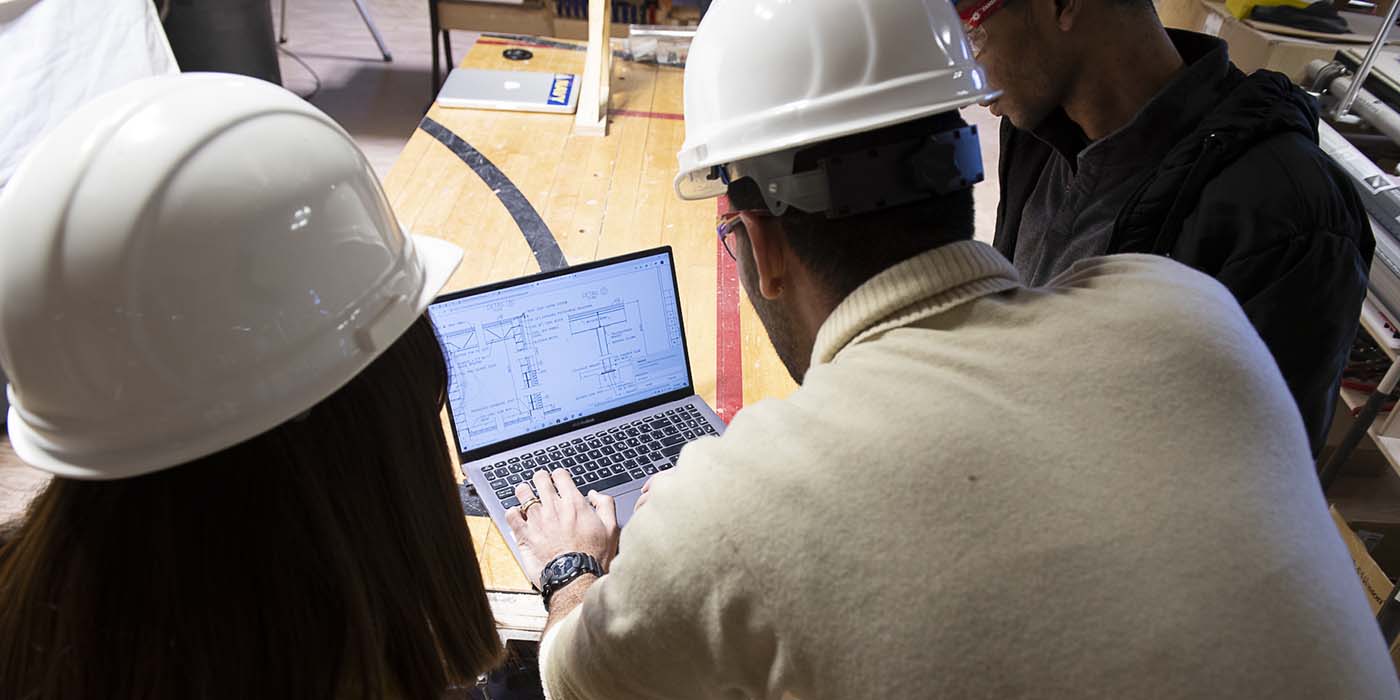 Building Technology students over a laptop