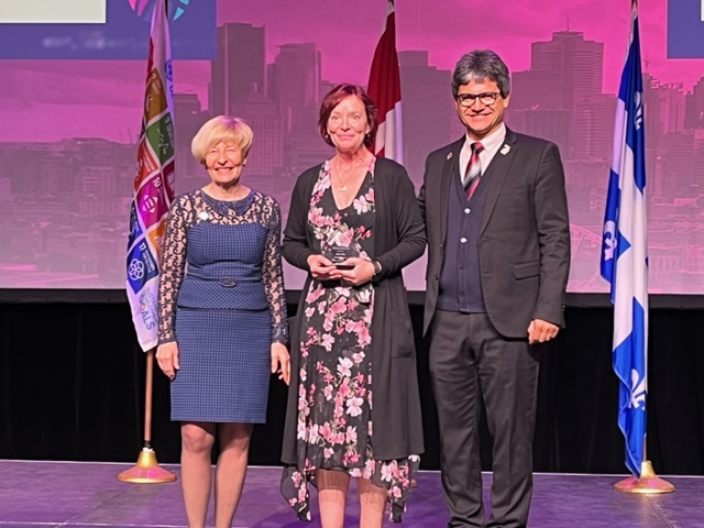 Fanshawe professor Karen Klee stands on stage with Denise Amyot, CEO of CICan and Glory Kambanja Mutungi, WFCP’s deputy chair of Africa to receive her award.