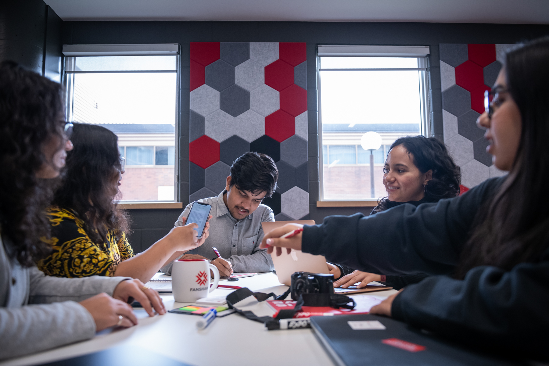 A group of students sitting at a table working on a project
