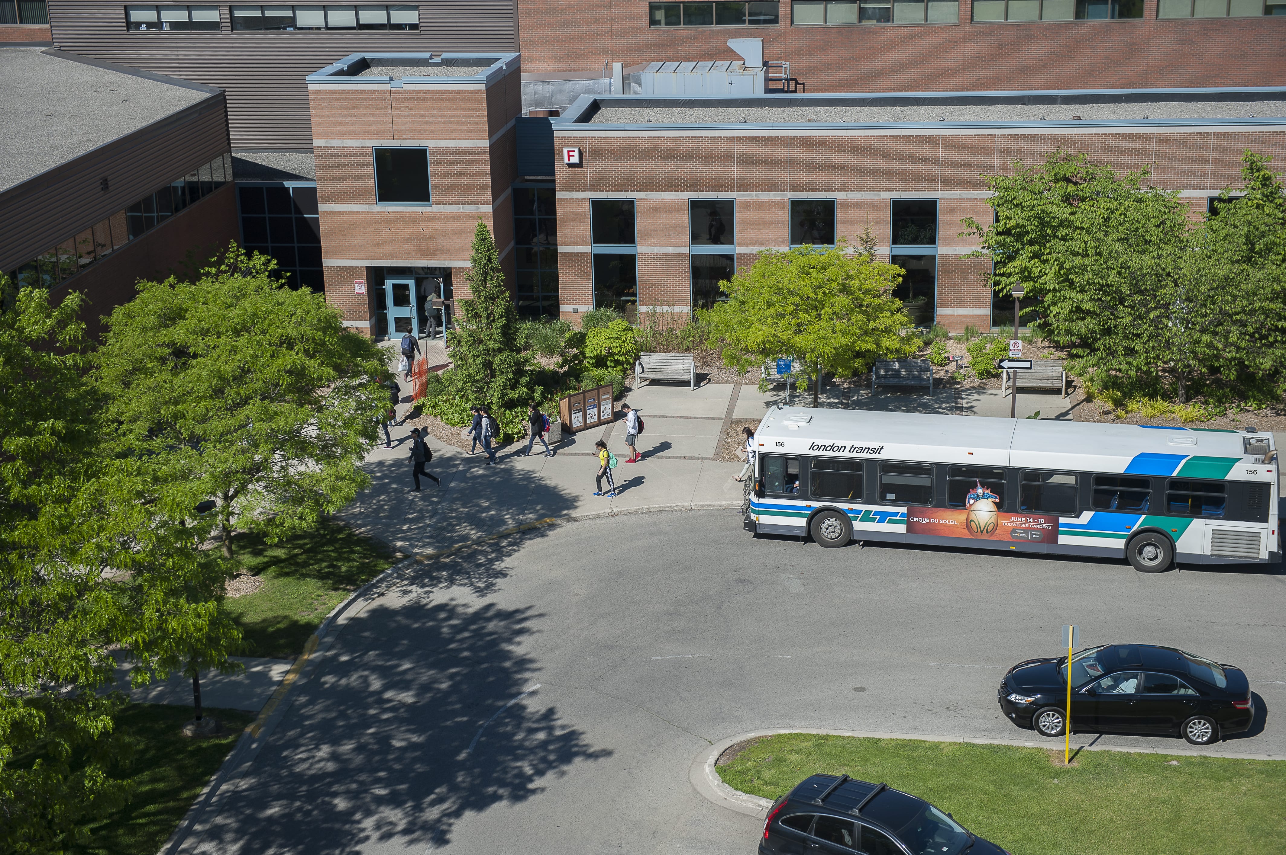 bus in front of building as students walk to class