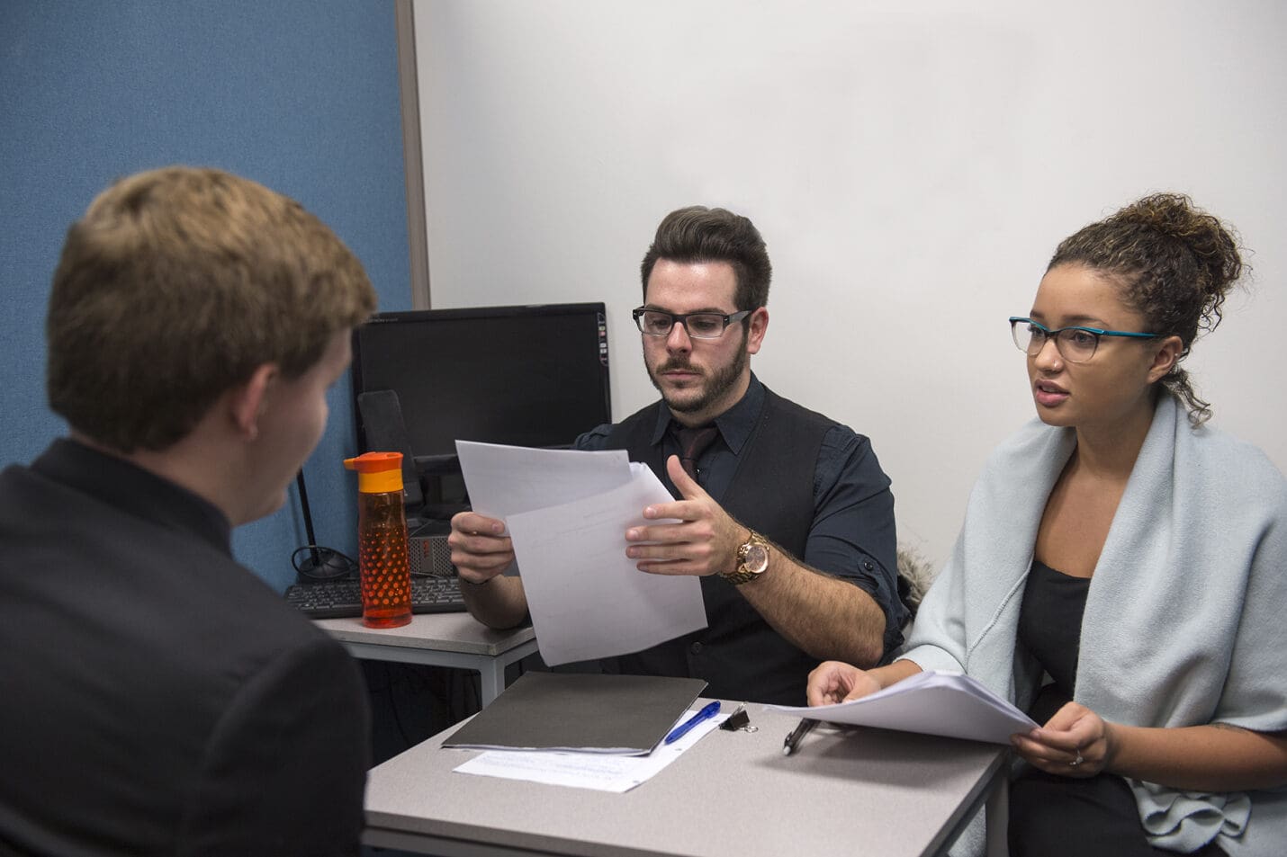 man and woman look at paperwork during employment interview