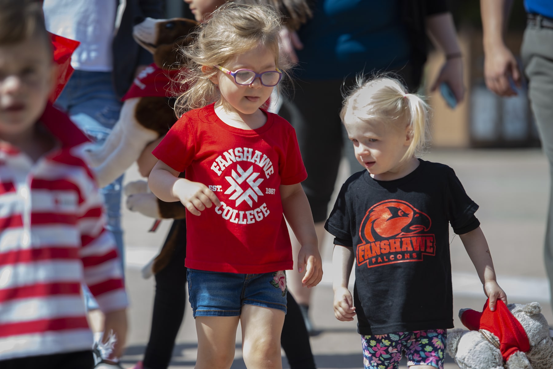 two small children walk side by side in fanshawe tshirts