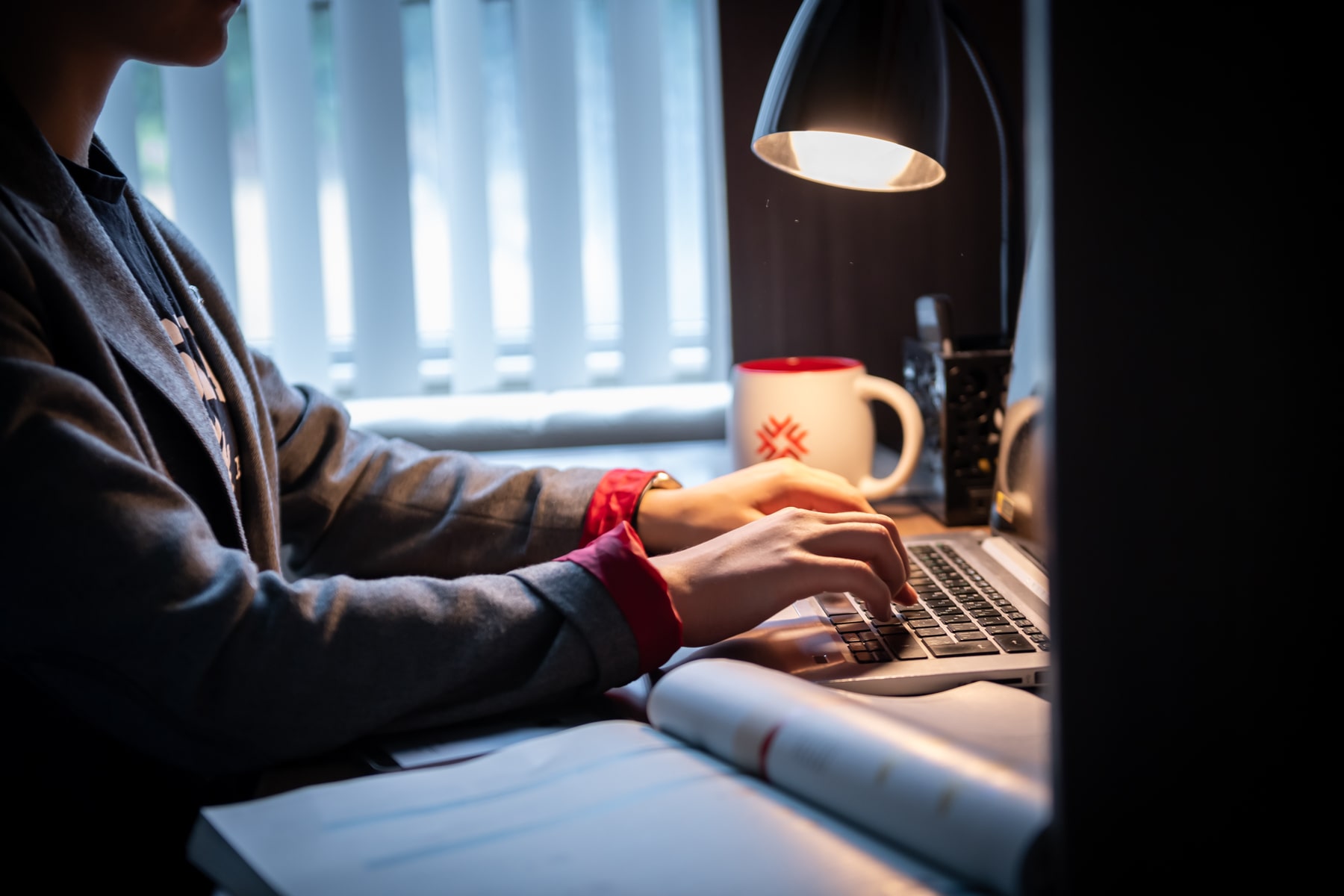 Student typing on a laptop at a desk