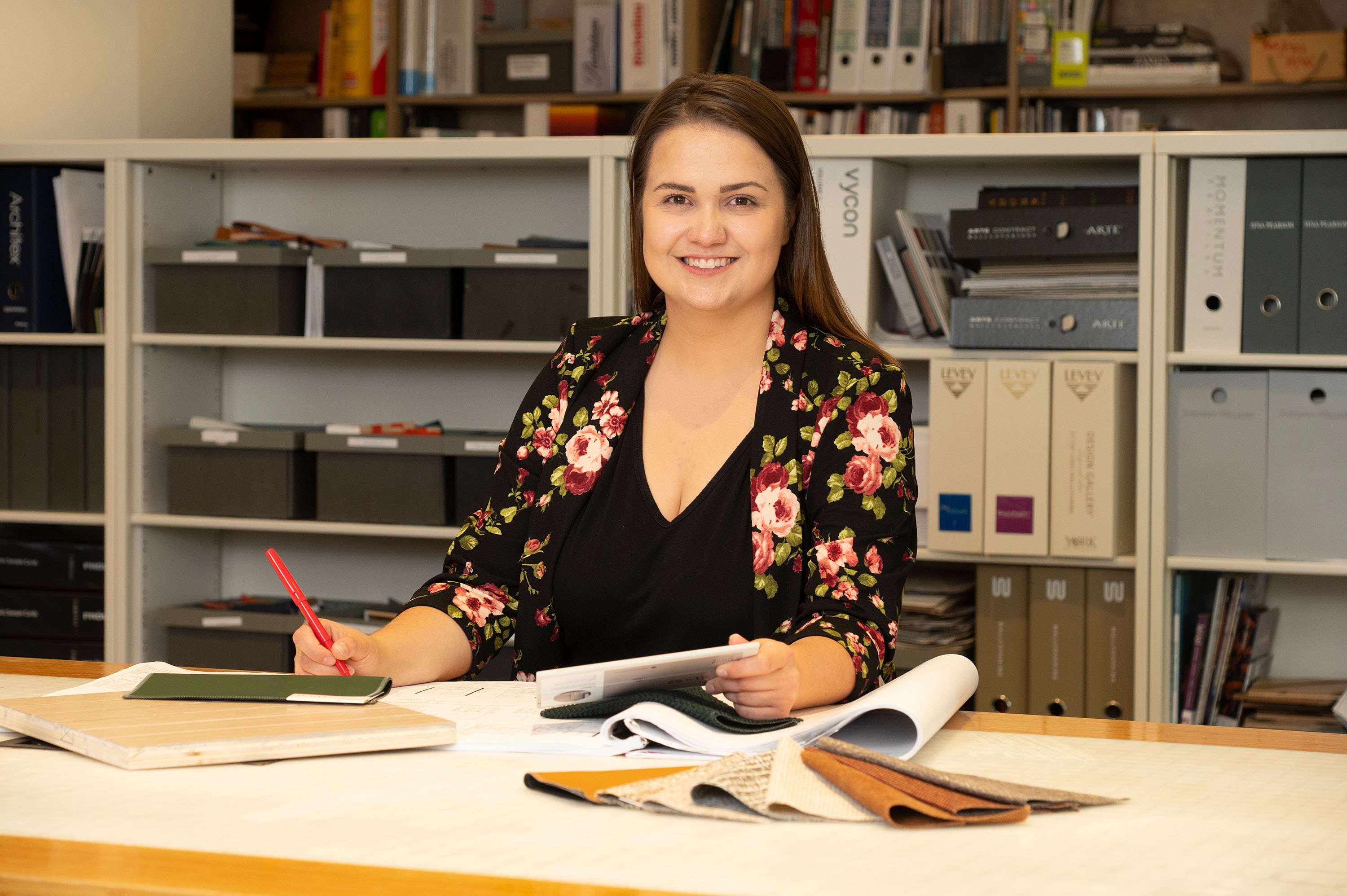 Photo of a design student posing at their desk during a co-op term